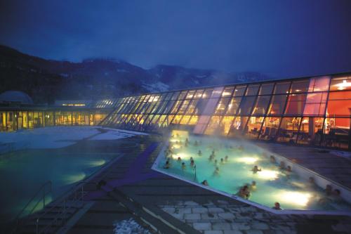 a building with a pool in front of it at night at Haus Piller in Bad Hofgastein