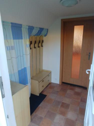 a room with a closet and a door and a tiled floor at Podkroví - ubytování Brdy in Bohutín
