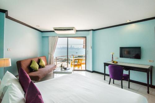 a bedroom with a bed and a desk and a couch at Bella Villa Metro in Pattaya North