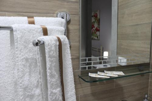ein Badezimmer mit weißen Handtüchern und einem Spiegel in der Unterkunft Bed & Breakfast San Marco in Taranto
