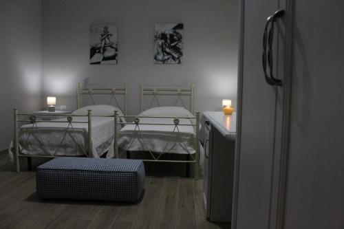a room with two beds and a table with a suitcase at Bed & Breakfast San Marco in Taranto