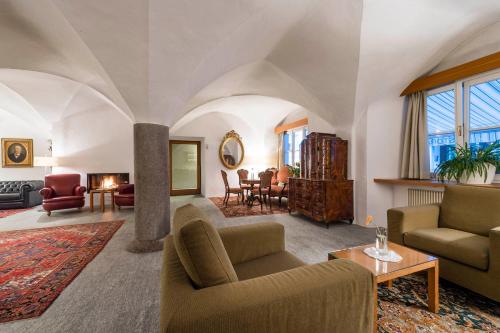 ein Wohnzimmer mit einem Sofa und einem Tisch in der Unterkunft Boutique & Gourmet Hotel Orso Grigio in Innichen