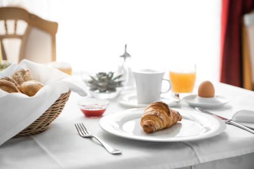 een tafel met een bord croissants en eieren erop bij Kristallhotel Corona-Krone in San Vigilio Di Marebbe