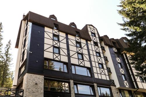 un edificio de apartamentos con ventanas en blanco y negro en Stella Bianca Apartman, en Jahorina