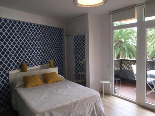 1 dormitorio con 1 cama con pared azul en Céntrico y coqueto apartamento, en Puerto de la Cruz