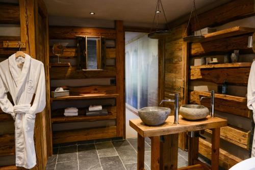 La salle de bains est pourvue de murs en bois et de 2 lavabos. dans l'établissement Chalets Grands Montets, à Chamonix-Mont-Blanc