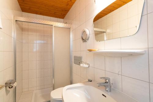 ein Badezimmer mit einem Waschbecken, einem WC und einem Spiegel in der Unterkunft Petererhof in Gerlos