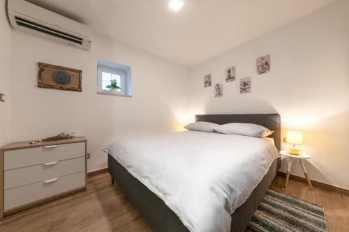 - une chambre avec un grand lit et une commode avec une table de chevet dans l'établissement Mariva Downtown Studio, à Rovinj