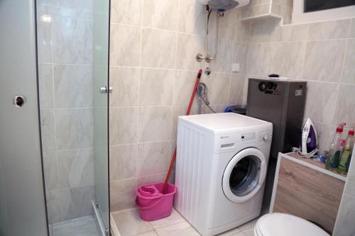 een badkamer met een wasmachine en een toilet bij Petars Apartment in Belgrado