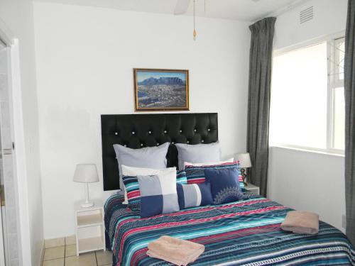 1 dormitorio con 1 cama grande y almohadas coloridas en Dumela Margate Flat No 14, en Margate
