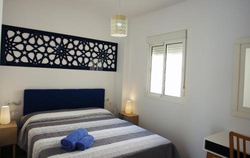 a small bedroom with a bed and a window at Apartamentos Costa de la Luz playa in Rota