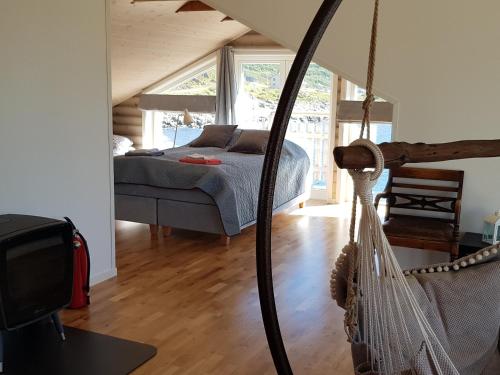 a bedroom with a bed and a hammock in a room at aurora suite in Nyksund