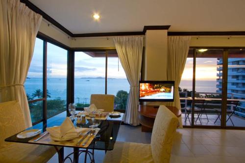 a living room with a dining table and a television at Bella Villa Metro in North Pattaya
