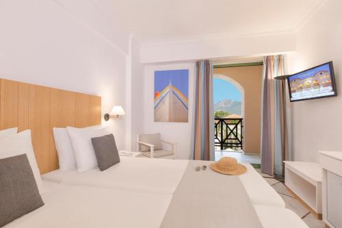 a bedroom with a large white bed and a balcony at Samaina Inn in Karlovasi