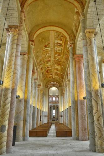 a hallway in a building with columns and a ceiling at Hôtel de France in Saint-Savin-sur-Gartempe