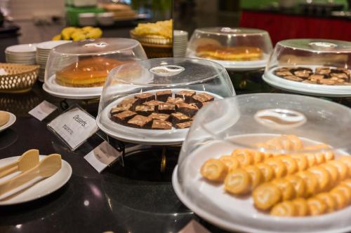 a table topped with trays of pastries and desserts at Bella Villa Metro in Pattaya North