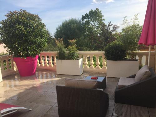 a patio with potted plants on a balcony at L'Escale de Jules et Lily in Bligny-lès-Beaune