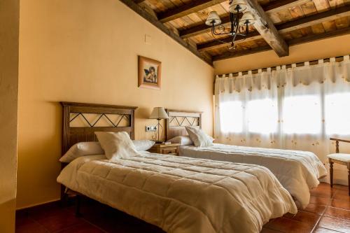 een slaapkamer met 2 bedden en een raam bij Casa Rural Caseta de los Camineros in Garrovillas