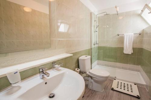uma casa de banho com um lavatório, um WC e um chuveiro em Murdeira Village Resort em Beirona