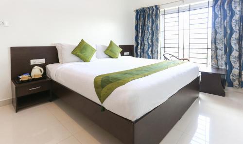 a large bed in a room with a large window at Treebo Light House, 900 Mtrs From Botanical Garden in Ooty
