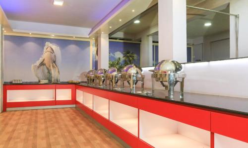 a buffet line with bowls and a painting on the wall at Treebo Light House, 900 Mtrs From Botanical Garden in Ooty