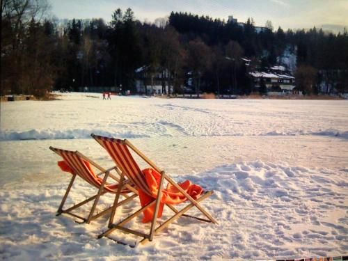 a beach chair sitting in the snow on a beach at Landhaus de Gaspary in Seehausen am Staffelsee