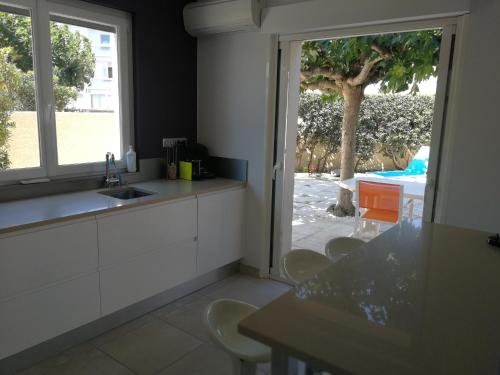 a kitchen with a sink and a table and a window at Belle maison, en bord de plage in Narbonne-Plage