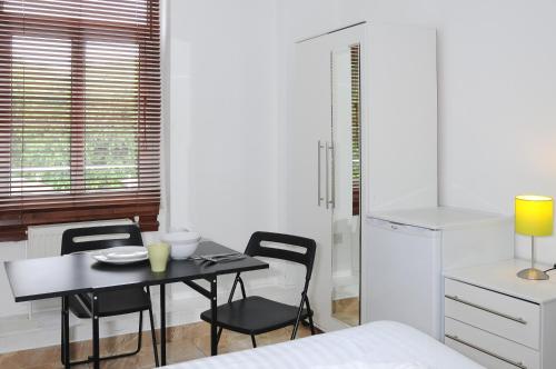 1 dormitorio con mesa, sillas y 1 cama en Abercorn House, en Londres