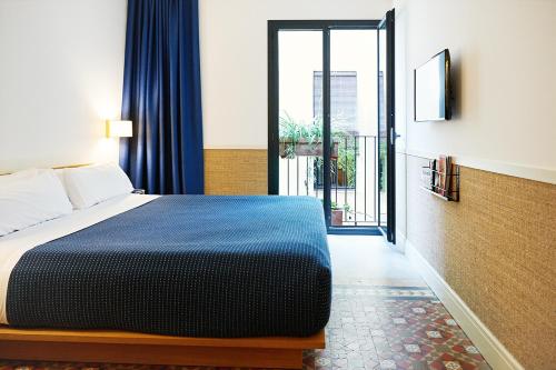 a bedroom with a bed and a window at Hotel Casa Bonay in Barcelona