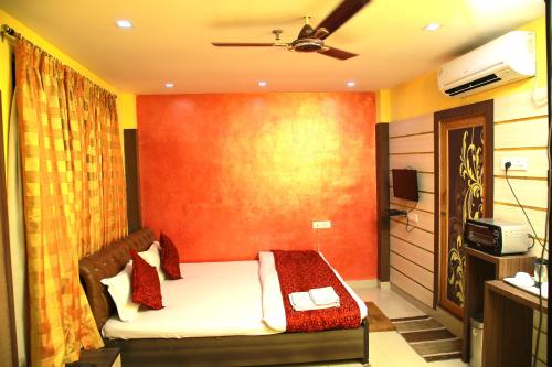 a bedroom with a bed and a television in it at Babul Hotel in Kolkata