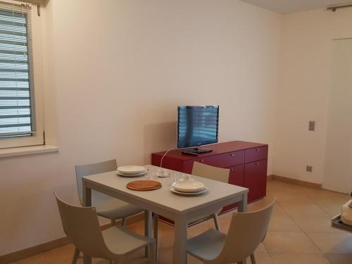 a dining room with a table and chairs and a tv at Prestige Apartments by Quokka 360 - spacious flats with terraces in Lugano