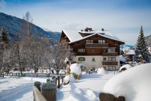 ein schneebedecktes Haus vor der Tür in der Unterkunft Sunstar Hotel Klosters in Klosters