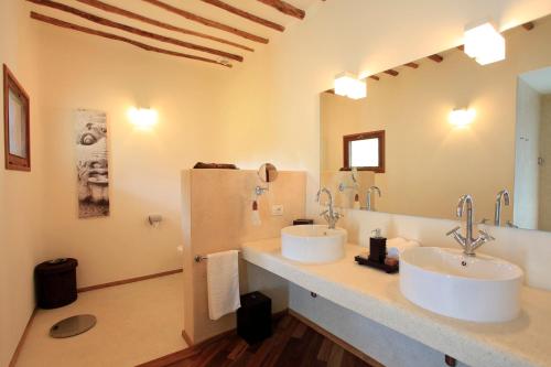 a bathroom with two sinks and a large mirror at Essque Zalu Zanzibar in Nungwi