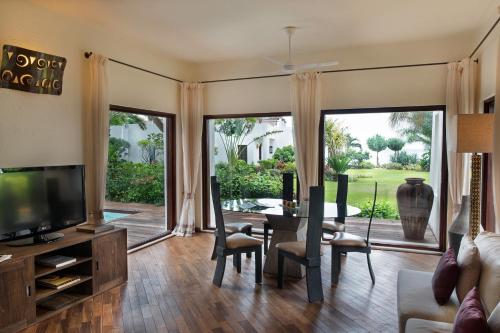a living room with a television and a table and chairs at Essque Zalu Zanzibar in Nungwi