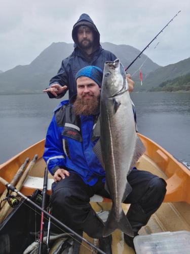 a man holding a fish in a boat at Gullesfjord Camping in Gullesfjord