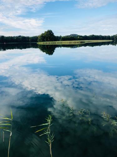 a large lake with clouds in the water at Seehotel Lichtenberg in Lichtenberg