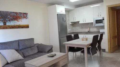 uma sala de estar e cozinha com um sofá e uma mesa em Apartamento Las Tortugas em Arroyo Frío
