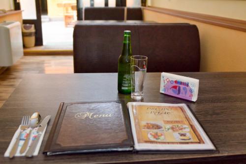 a bottle of wine and a book on a table at Hotel Rade 1 in Vratsa