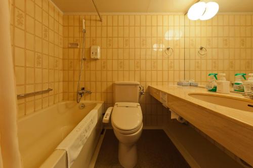La salle de bains est pourvue de toilettes, d'une baignoire et d'un lavabo. dans l'établissement Morioka Grand Hotel Annex, à Morioka