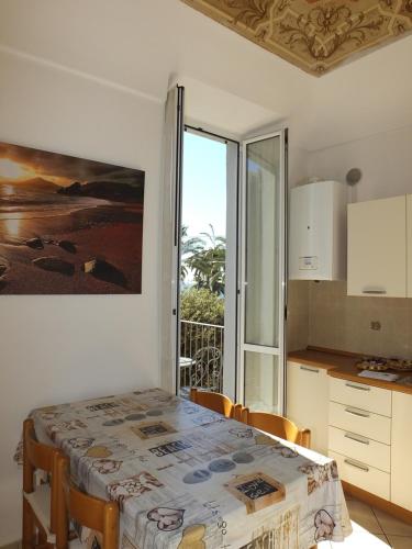 a kitchen with a table with chairs and a window at Casa Amico Mare in Loano