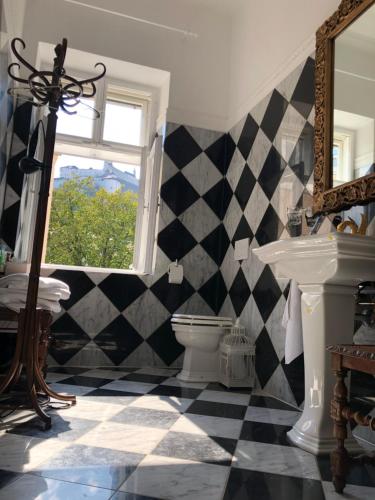 een badkamer met een zwart-wit geruite vloer bij Sarah's Altstadt Oase Salzburg in Salzburg