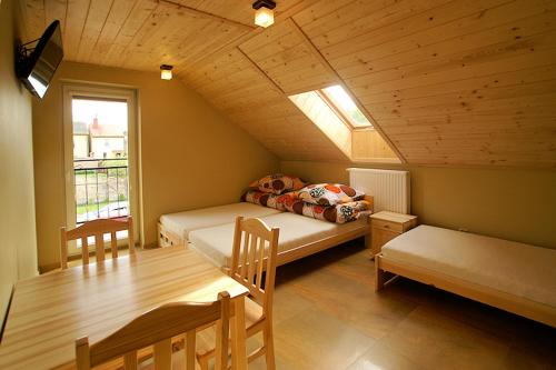 a room with two beds and a table and a window at Agroturystyka Katarzyna in Święta Katarzyna