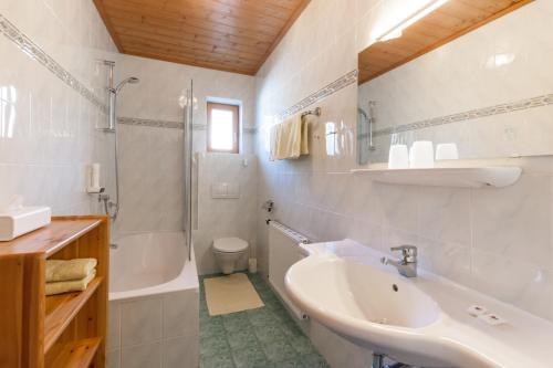 Un baño blanco con lavabo y ducha. en Noichl’s Hotel Garni, en Sankt Johann in Tirol