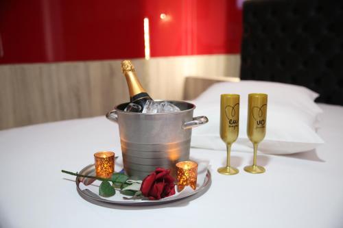 Una botella de champán en un cubo sobre una mesa en Motel 2001 (Adults Only), en São José