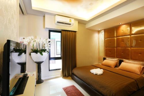 un dormitorio con una cama con un gato sobre ella en The Luxury Residence, en Songkhla