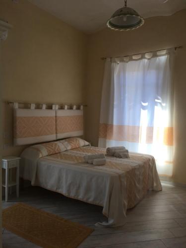 1 dormitorio con 1 cama con 2 toallas en Guest House Le Gemelle, en Luras