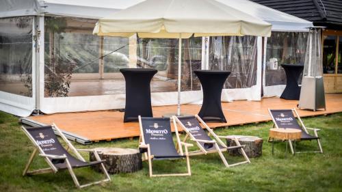 a tent with two chairs and a table in the grass at Hotel Jakubus in Wilków