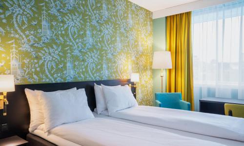 a bedroom with a bed and a blue and yellow wall at Thon Hotel Maritim in Stavanger