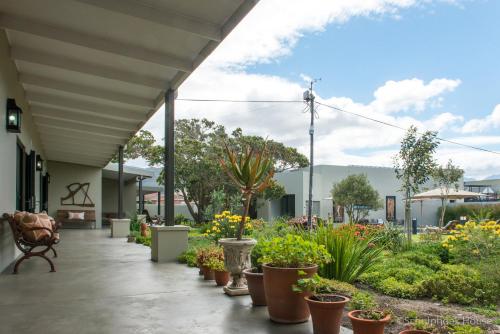 a porch with potted plants and a garden at Schulphoek Seafront House in Hermanus