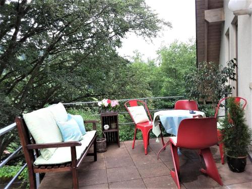Un patio con sillas y una mesa en el balcón. en Ferienwohnung Ringbergblick en Suhl
